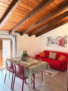 a living room with a red couch and a table at Agriturismo Cornei da Nadia in Collio +39 photos