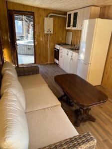 a living room with a couch and a table and a refrigerator at Bardzunq Garden Resort in Goghtʼ