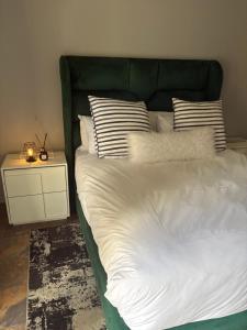 a bed with a green headboard and pillows on it at Unit 7-9 at Homely Escapes in Phalaborwa