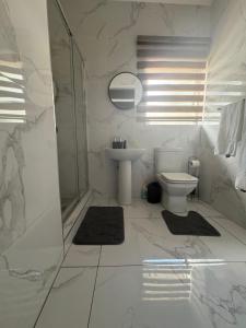 a white bathroom with a toilet and a sink at Unit 7-9 at Homely Escapes in Phalaborwa +13 photos