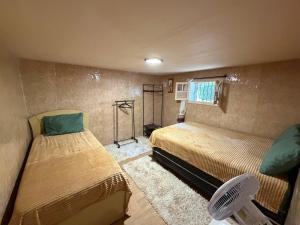 a small room with two beds and a window at Cantinho do Imperador in Petrópolis
