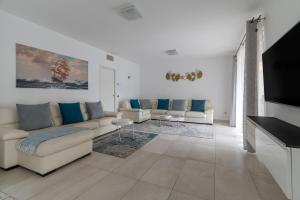 a living room with couches and a flat screen tv at Elegant Lake View Apartment with Pool in Lavena Ponte Tresa