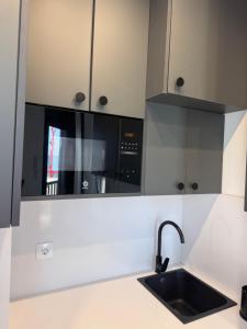 a kitchen with a black microwave above a sink at MINA MAR 1ª línea playa ADULTS ONLY in Vinarós