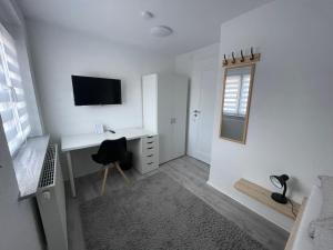 a white room with a desk and a television at 5-Täler Stern in Geislingen an der Steige
