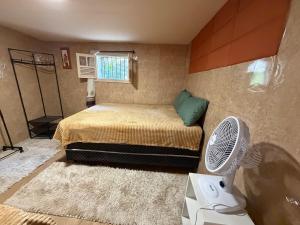 a small bedroom with a bed and a fan at Cantinho do Imperador in Petrópolis