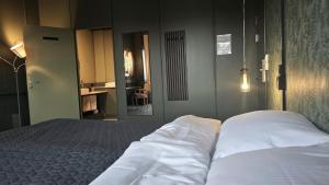 a bedroom with a bed with white sheets at Kuben Utleie in Narvik