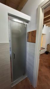 a glass shower door in a room with a tile floor at Il Castellaro ai Sassi in Guiglia +66 photos