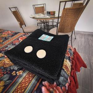 a black blanket sitting on a bed with a table at Hospedaje Don Juve in Atlixco