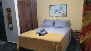 una cama con dos almohadas encima en Pousada Costa Verde Tabatinga, en Ubatuba
