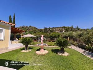 a garden with a statue of a woman on a fountain at Elisabeth Villas in Kerveli
