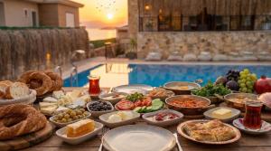 a buffet of food on a table next to a pool at Stone House Foça Otel in Yenifoça