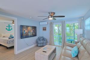 a living room with a couch and a tv on a wall at The Inn on Siesta Key in Siesta Key