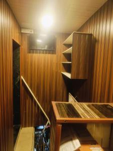 a room with a wooden wall with a table and a tv at Farhan DORMITORY in Mumbai
