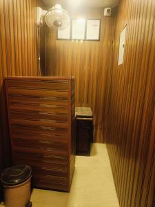 a room with a wood paneled room with a fan at Farhan DORMITORY in Mumbai