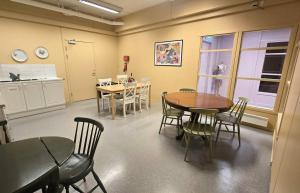 a room with a table and chairs and a kitchen at Kuben Utleie in Narvik