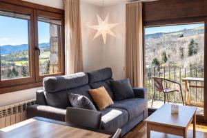 a living room with a couch and a large window at Allotjaments Pirineus in Molló