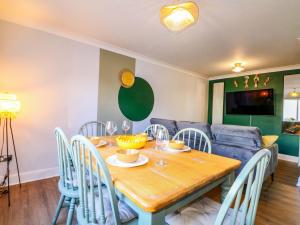 a dining room with a wooden table and chairs at Farnham Park Apartment in Farnham