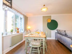 a dining room with a table and chairs and a couch at Farnham Park Apartment in Farnham