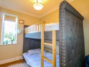a bunk bed room with two bunk beds and a window at Farnham Park Apartment in Farnham