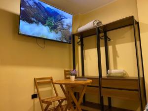a room with a table and a tv on the wall at Posada Miraflores in Lima