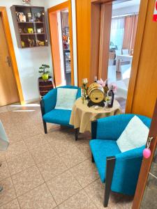 a living room with two blue chairs and a table at Wellness Hotel Staré Město in Uherské Hradiště