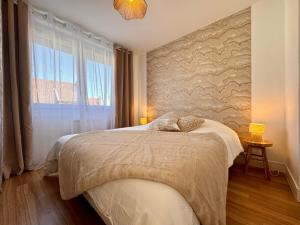 a bedroom with a bed and a large window at Le Nid Doré in Calais