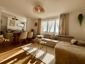 a living room with a couch and a table and a kitchen at Le Nid Doré in Calais