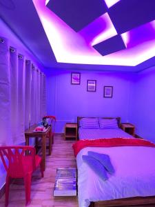 a purple bedroom with a bed and a table at Chug Ling Serene in Chug +9 photos