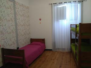 Un dormitorio pequeño con una cama y una ventana. en Hostel Raymundo, en Évora
