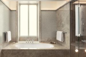 a bathroom with a tub and a window at Bvlgari Hotel Roma in Rome