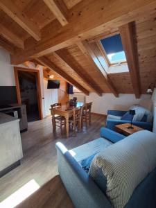 a living room with a blue couch and a table at Cà mea Dina Apartments in Ledro