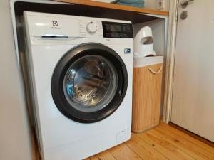 a white washing machine in a room with a wooden floor at Tartu tänava külaliskorter in Viljandi