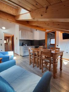 a kitchen and living room with a wooden table and chairs at Cà mea Dina Apartments in Ledro