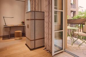 a room with a sliding glass door and a room with a piano at Bvlgari Hotel Roma in Rome