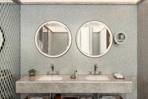 three mirrors above two sinks in a bathroom at Bvlgari Hotel Roma in Rome