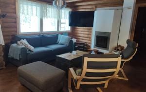 a living room with a blue couch and a chair at Kaijonselän mökit Pyhitty in Vehmaskylä