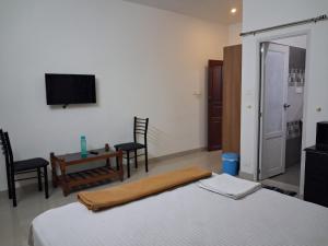 a bedroom with a bed and a table and a tv at Love Villa in Kottiyam
