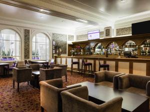 a bar in a restaurant with tables and chairs at Mercure Aberdeen Caledonian Hotel in Aberdeen