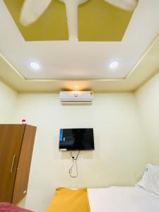 a bedroom with a tv on the wall and a bed at Vishwa Heritage Ellora in Ellora