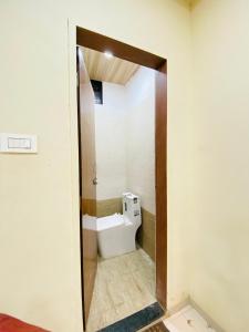 a bathroom with a toilet through a doorway at Vishwa Heritage Ellora in Ellora