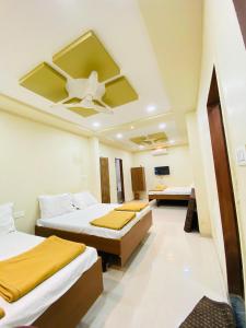 a bedroom with two beds and a ceiling fan at Vishwa Heritage Ellora in Ellora