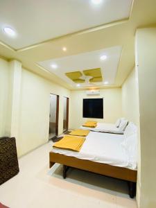 a bedroom with a bed and a flat screen tv at Vishwa Heritage Ellora in Ellora