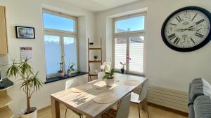 a dining room with a table and a clock on the wall at Studio Frohburg Gommiswald in Gommiswald