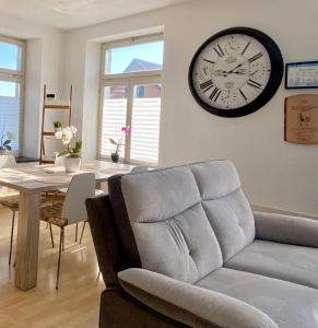 a living room with a couch and a clock on the wall at Studio Frohburg Gommiswald in Gommiswald +3 photos
