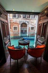 a view of a pool from a room with chairs and a table at Ruzzini Palace Hotel in Venice