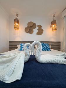 two swans are sitting on two beds in a bedroom at Pousada Villa Mar Porto in Porto De Galinhas