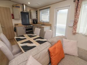 a living room with a couch and a kitchen at Cresswell Towers in Morpeth