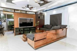 a living room with a couch and a flat screen tv at Jhenk's Guesthouse in Coleto