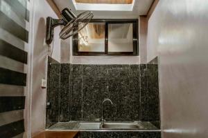 a bathroom with a sink and a fan at Jhenk's Guesthouse in Coleto +23 photos