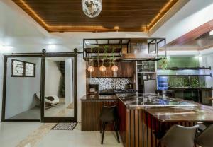 a kitchen with a counter and a bar with stools at Jhenk's Guesthouse in Coleto